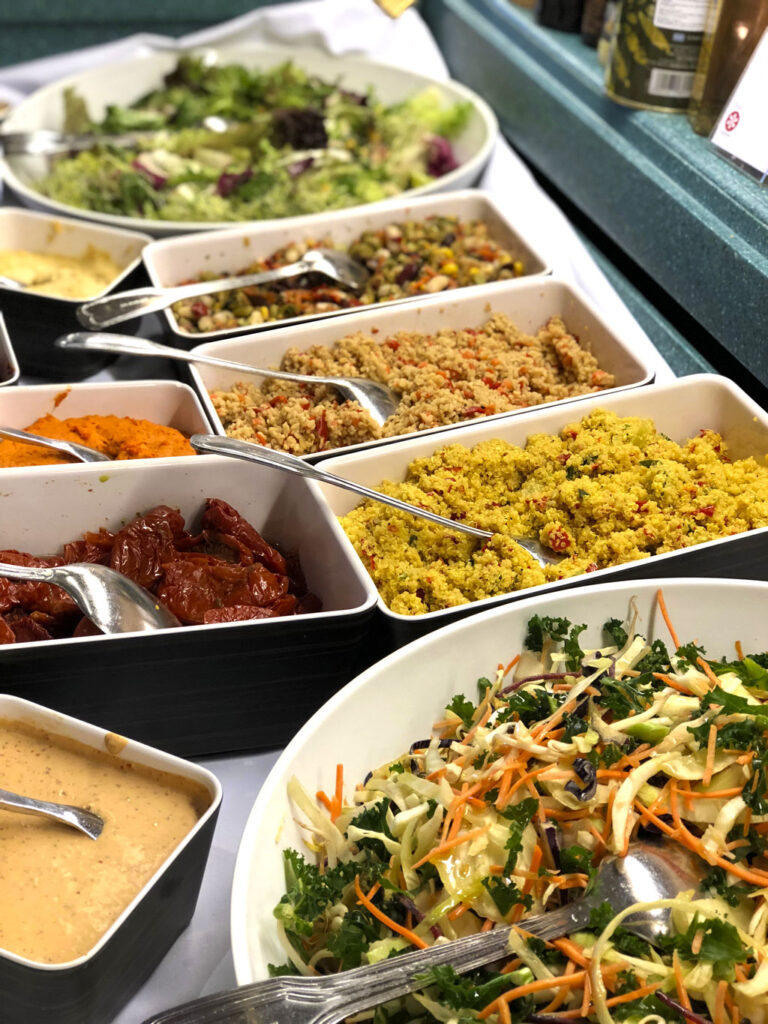 Nærbilde av retter på en buffé. Salat, couscous, soltørket tomat med mer.